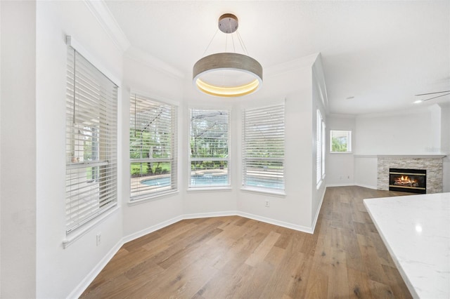 17802 Mission Oak Dr, Lithia, FL 33547 - unfurnished dining area featuring ornamental molding, wood finished floors, baseboards, and a glass covered fireplace