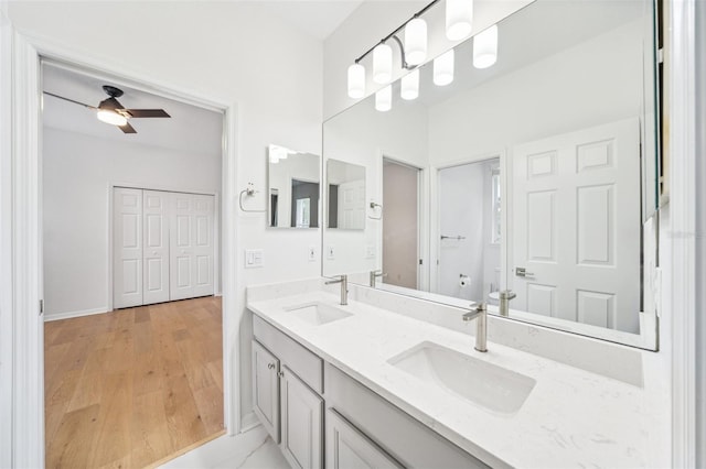 17802 Mission Oak Dr, Lithia, FL 33547 - bathroom featuring double vanity, a ceiling fan, toilet, wood finished floors, and baseboards