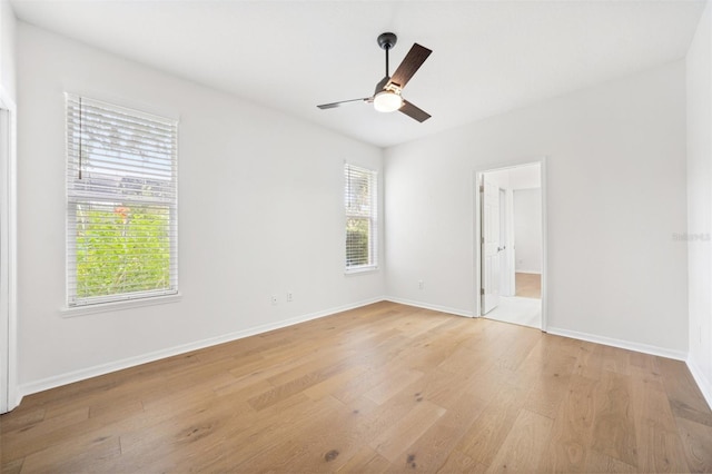 17802 Mission Oak Dr, Lithia, FL 33547 - unfurnished bedroom with light wood finished floors, multiple windows, baseboards, and ceiling fan