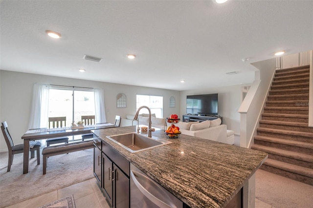 7641 Sail Clover Ln, Zephyrhills, FL 33540 - kitchen with a sink, stainless steel dishwasher, a center island with sink, open floor plan, and dark stone counters