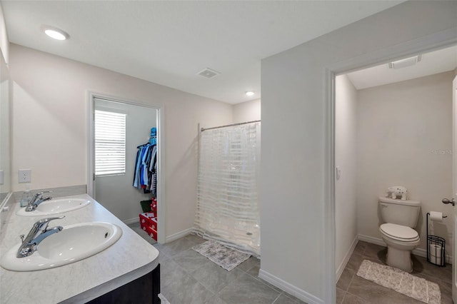 7641 Sail Clover Ln, Zephyrhills, FL 33540 - full bath with double vanity, toilet, a shower with shower curtain, tile patterned flooring, and baseboards