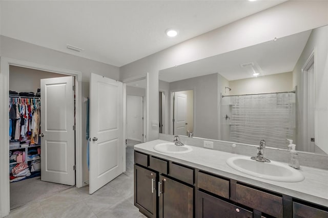 7641 Sail Clover Ln, Zephyrhills, FL 33540 - full bathroom with double vanity, a spacious closet, a shower, and tile patterned flooring
