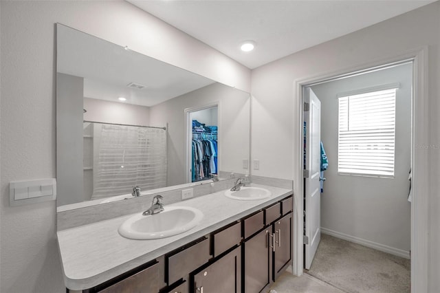 7641 Sail Clover Ln, Zephyrhills, FL 33540 - bathroom with double vanity, a walk in closet, baseboards, and a shower with curtain