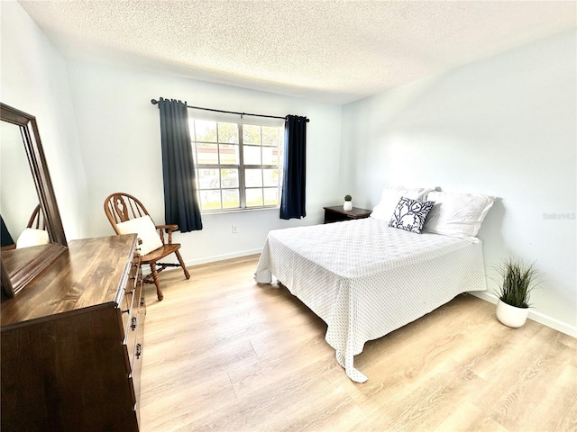 13926 Mission Oaks Blvd, Seminole, FL 33776 - bedroom featuring light wood-type flooring, baseboards, and a textured ceiling