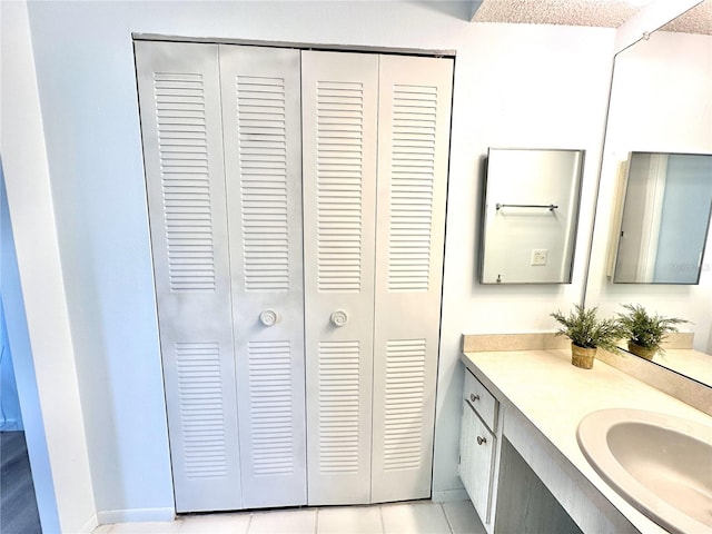 13926 Mission Oaks Blvd, Seminole, FL 33776 - bathroom with a closet, vanity, tile patterned floors, and baseboards