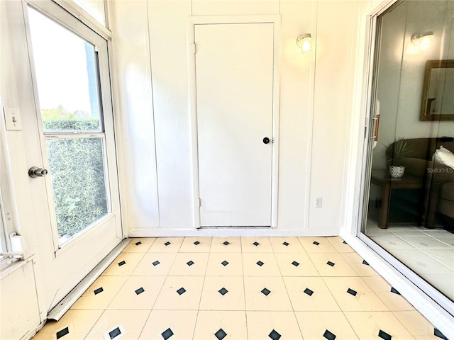 13926 Mission Oaks Blvd, Seminole, FL 33776 - doorway to outside with healthy amount of natural light and light tile patterned flooring