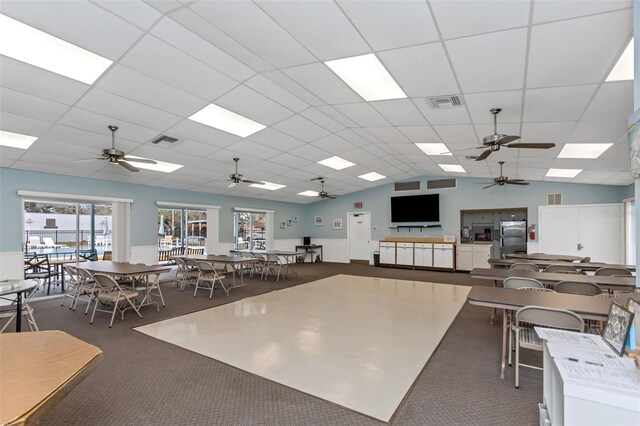 13926 Mission Oaks Blvd, Seminole, FL 33776 - carpeted dining area featuring a ceiling fan and a paneled ceiling