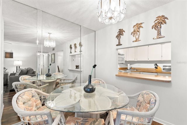 2699 Pine Ridge Way E Unit H2, Palm Harbor, FL 34684 - dining area featuring a chandelier, wood finished floors, and a textured ceiling
