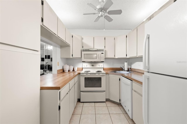 2699 Pine Ridge Way E Unit H2, Palm Harbor, FL 34684 - kitchen with white appliances, ceiling fan, and light tile patterned floors