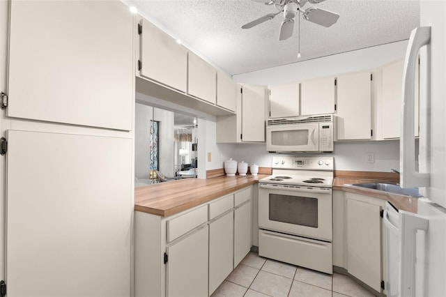 2699 Pine Ridge Way E Unit H2, Palm Harbor, FL 34684 - kitchen with white appliances, ceiling fan, light countertops, a textured ceiling, and light tile patterned floors