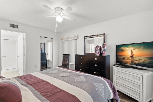 2699 Pine Ridge Way E Unit H2, Palm Harbor, FL 34684 - bedroom featuring a ceiling fan, a textured ceiling, and connected bathroom