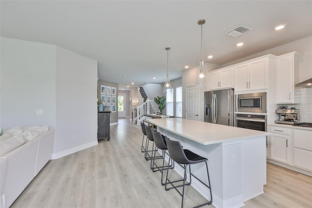 5511 Del Coronado Dr, Apollo Beach, FL 33572 - kitchen featuring appliances with stainless steel finishes, open floor plan, light wood finished floors, a kitchen island, and recessed lighting