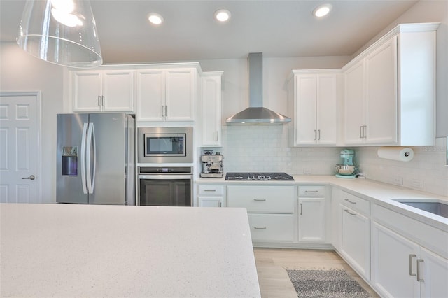 5511 Del Coronado Dr, Apollo Beach, FL 33572 - kitchen with wall chimney exhaust hood, appliances with stainless steel finishes, light countertops, white cabinets, and recessed lighting