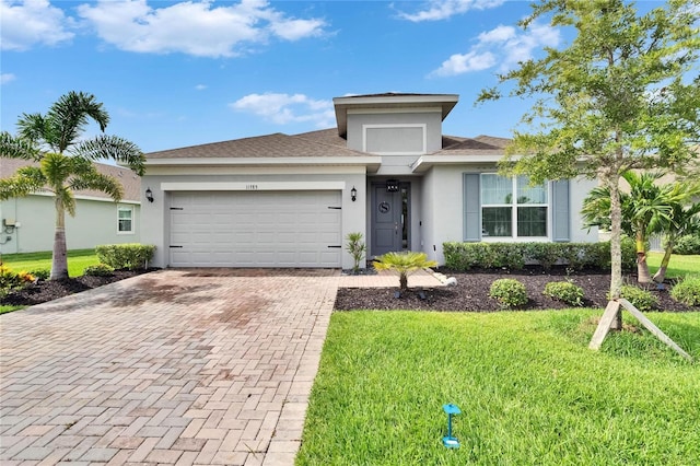 11785 Little River Way, Parrish, FL 34219 - view of front of home featuring decorative driveway, an attached garage, stucco siding, and a front yard