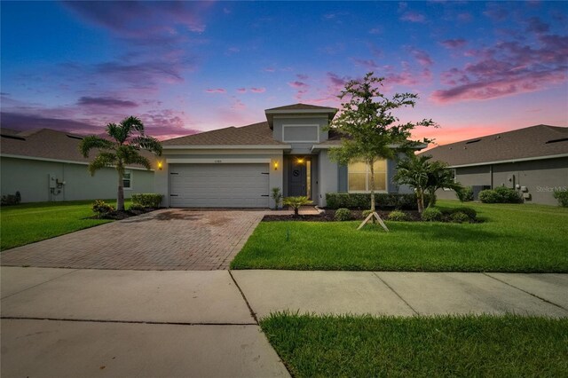 11785 Little River Way, Parrish, FL 34219 - view of front of property featuring decorative driveway, a garage, stucco siding, and a lawn
