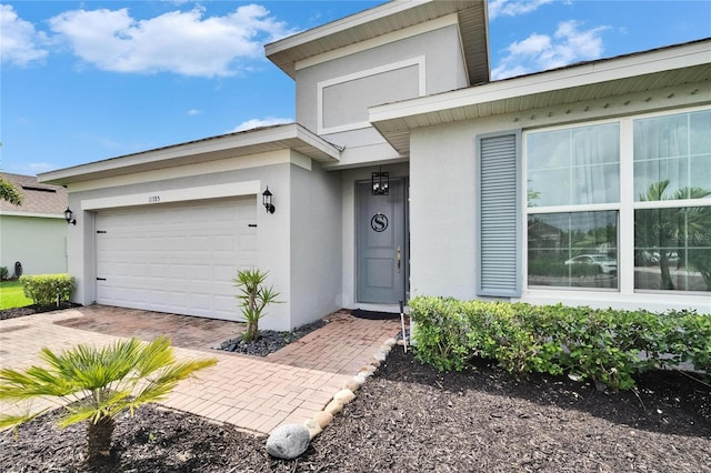 11785 Little River Way, Parrish, FL 34219 - entrance to property with stucco siding, a garage, and decorative driveway