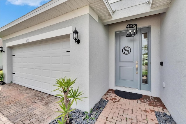 11785 Little River Way, Parrish, FL 34219 - entrance to property with stucco siding, an attached garage, and decorative driveway