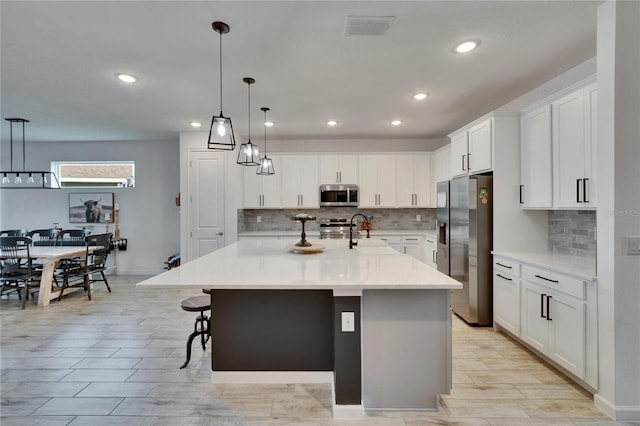 11785 Little River Way, Parrish, FL 34219 - kitchen with stainless steel appliances, backsplash, light countertops, white cabinets, and recessed lighting