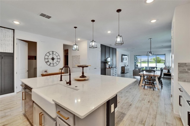 11785 Little River Way, Parrish, FL 34219 - kitchen with a sink, dishwasher, recessed lighting, light wood-type flooring, and a center island with sink