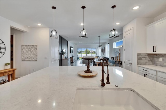 11785 Little River Way, Parrish, FL 34219 - kitchen with recessed lighting, light stone countertops, a sink, white cabinets, and decorative backsplash