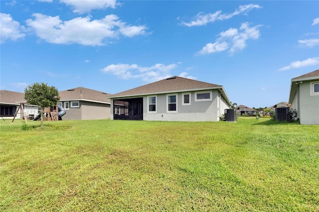 11785 Little River Way, Parrish, FL 34219 - rear view of property with central AC unit, stucco siding, a yard, and a sunroom
