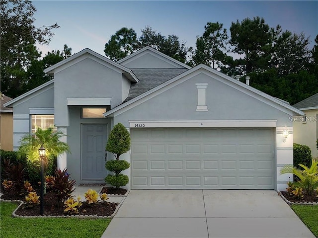 14320 Tree Swallow Way, Lakewood Ranch, FL 34202 - view of front of home with a garage, driveway, stucco siding, and a shingled roof