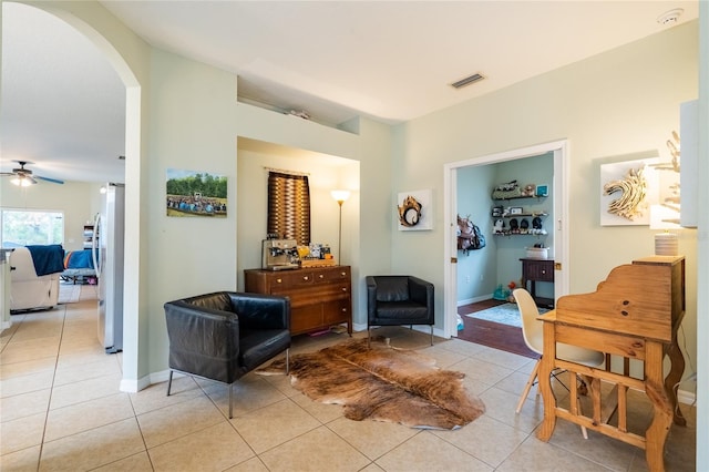 14320 Tree Swallow Way, Lakewood Ranch, FL 34202 - living area featuring light tile patterned flooring, arched walkways, ceiling fan, and baseboards