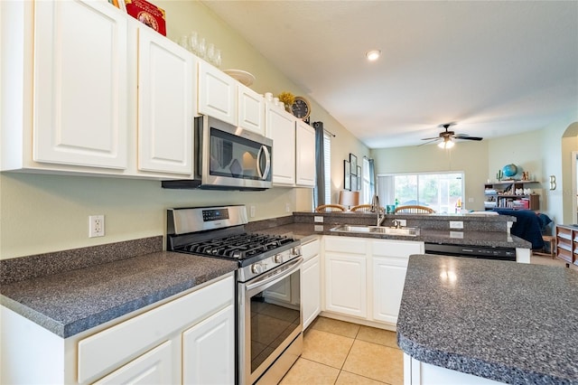 14320 Tree Swallow Way, Lakewood Ranch, FL 34202 - kitchen with appliances with stainless steel finishes, a sink, dark countertops, a peninsula, and a ceiling fan
