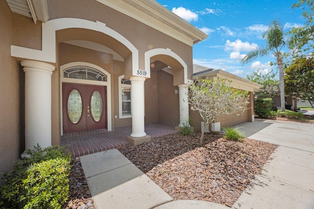 5519 Reflections Blvd, Lutz, FL 33558 - view of exterior entry featuring driveway, stucco siding, and a garage