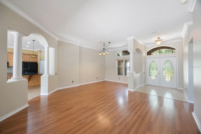 5519 Reflections Blvd, Lutz, FL 33558 - entrance foyer featuring decorative columns, a chandelier, ornamental molding, light wood-style floors, and arched walkways