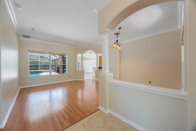 5519 Reflections Blvd, Lutz, FL 33558 - empty room with arched walkways, decorative columns, baseboards, crown molding, and light wood finished floors