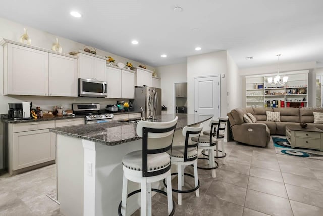 5006 Jackel Chase Dr, Wimauma, FL 33598 - kitchen with stainless steel appliances, a chandelier, a kitchen bar, a center island with sink, and recessed lighting