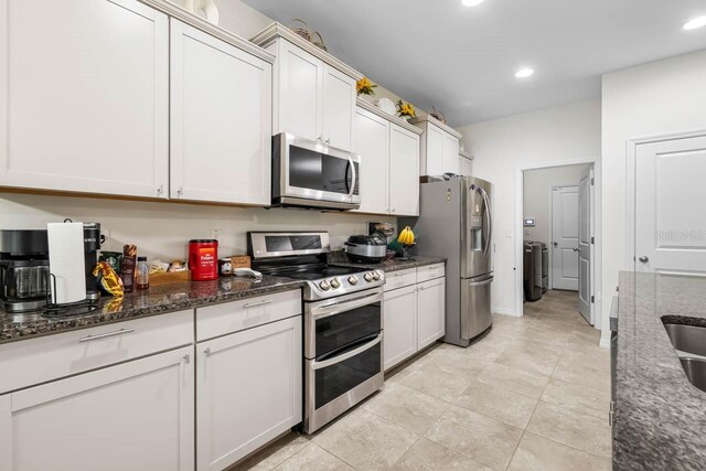 5006 Jackel Chase Dr, Wimauma, FL 33598 - kitchen featuring appliances with stainless steel finishes, dark stone countertops, recessed lighting, light tile patterned floors, and washer / dryer