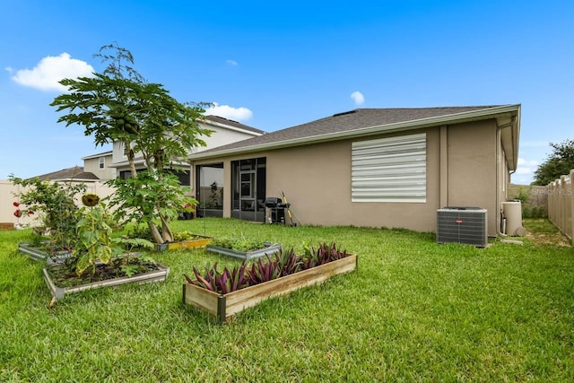 5006 Jackel Chase Dr, Wimauma, FL 33598 - rear view of property with central AC unit, a vegetable garden, stucco siding, and roof with shingles