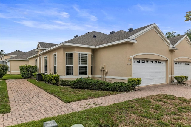2616 Tottenham Dr, New Port Richey, FL 34655 - view of front of property featuring stucco siding, a garage, decorative driveway, and a shingled roof