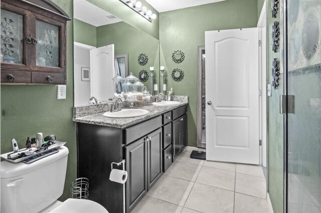 3901 Silverlake Way, Wesley Chapel, FL 33544 - bathroom featuring a textured wall, double vanity, tile patterned floors, toilet, and a shower stall