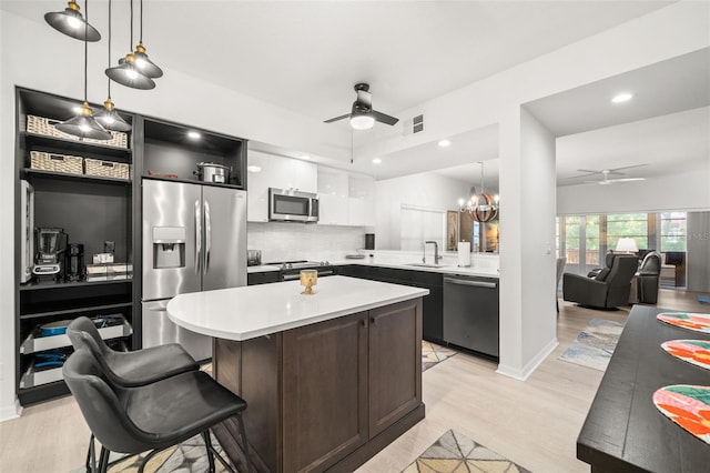 6330 99th Way N Unit 14B, Seminole, FL 33708 - kitchen with appliances with stainless steel finishes, ceiling fan, a sink, light countertops, and light wood-style flooring