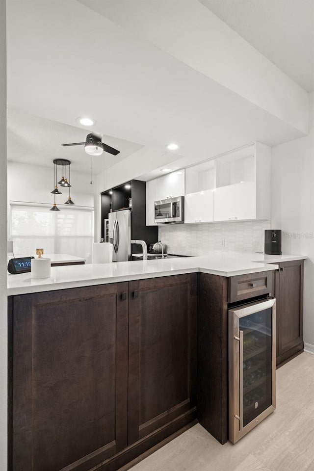 6330 99th Way N Unit 14B, Seminole, FL 33708 - kitchen with beverage cooler, appliances with stainless steel finishes, white cabinets, light countertops, and recessed lighting