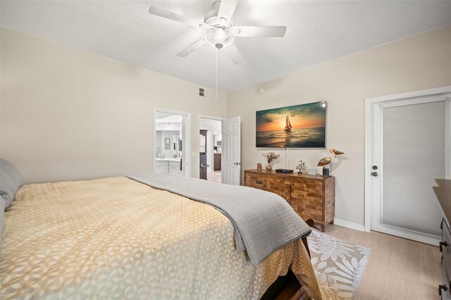 6330 99th Way N Unit 14B, Seminole, FL 33708 - bedroom with wood finished floors, ceiling fan, and ensuite bathroom