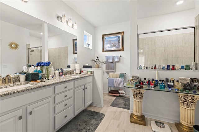 944 Old Windsor Way, Spring Hill, FL 34609 - bathroom featuring double vanity, a tile shower, and wood finished floors