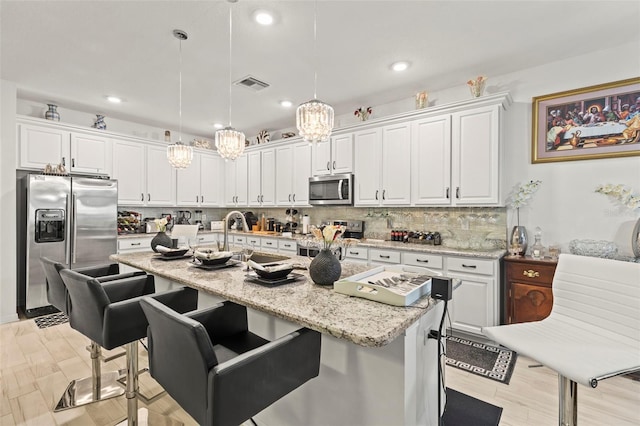 944 Old Windsor Way, Spring Hill, FL 34609 - kitchen with appliances with stainless steel finishes, a center island with sink, a sink, white cabinets, and decorative backsplash
