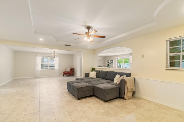 39721 Meadowood Loop, Zephyrhills, FL 33542 - living area featuring a tray ceiling, ceiling fan, a chandelier, light tile patterned flooring, and wainscoting