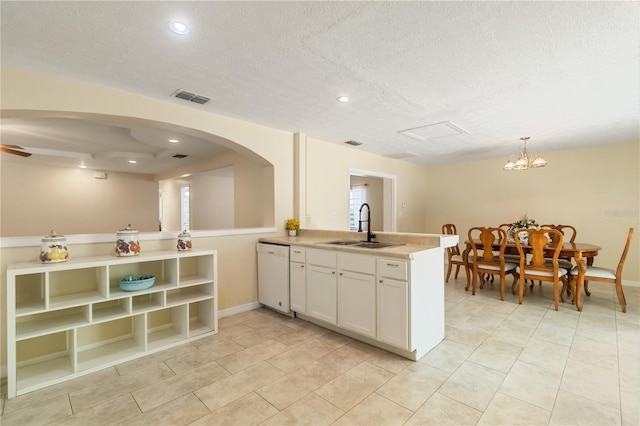 39721 Meadowood Loop, Zephyrhills, FL 33542 - kitchen with dishwasher, a sink, a peninsula, white cabinets, and light countertops