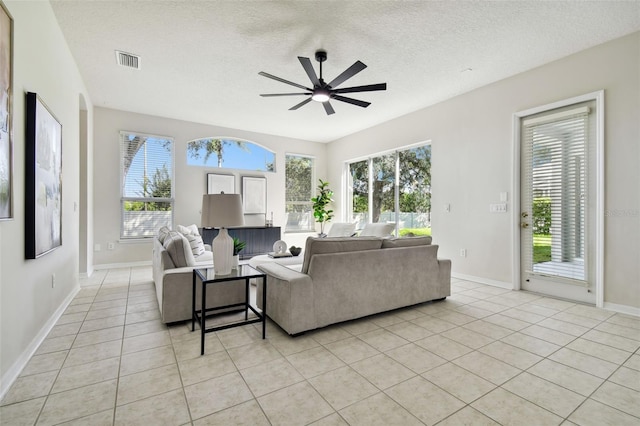 10244 Shadow Branch Dr, Tampa, FL 33647 - living room featuring ceiling fan, light tile patterned flooring, baseboards, and a textured ceiling