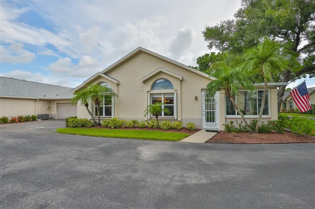 1111 Golfview Woods Dr Unit 1111, Sun City Center, FL 33573 - view of front of property featuring a garage, asphalt driveway, and stucco siding