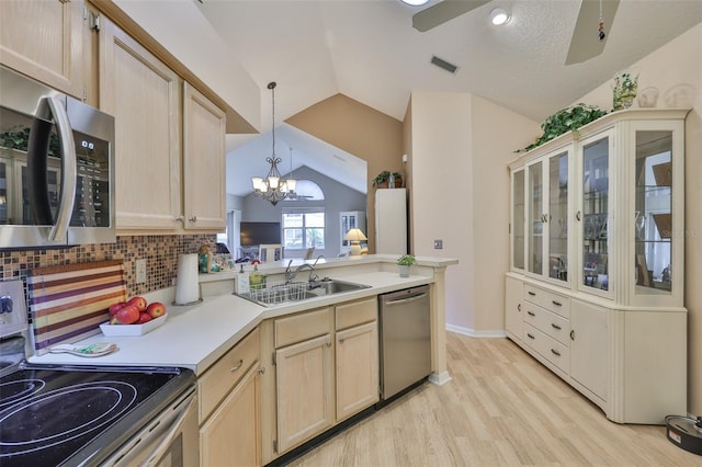 1111 Golfview Woods Dr Unit 1111, Sun City Center, FL 33573 - kitchen featuring stainless steel appliances, light brown cabinetry, a sink, vaulted ceiling, and light wood-style floors