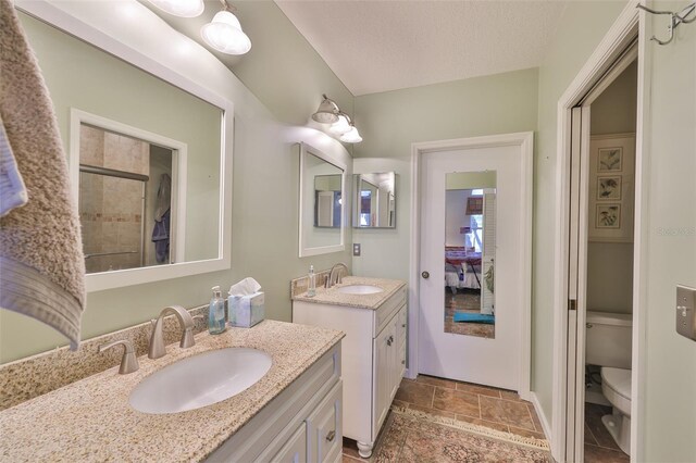 1111 Golfview Woods Dr Unit 1111, Sun City Center, FL 33573 - bathroom featuring toilet, two vanities, stone finish flooring, a tile shower, and baseboards