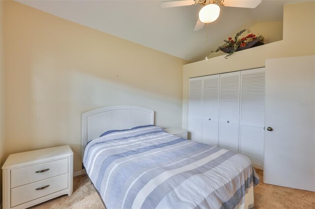 1111 Golfview Woods Dr Unit 1111, Sun City Center, FL 33573 - bedroom featuring light colored carpet, vaulted ceiling, a closet, and ceiling fan