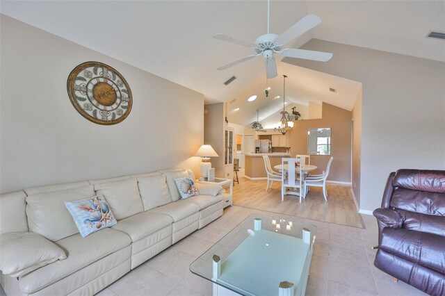 1111 Golfview Woods Dr Unit 1111, Sun City Center, FL 33573 - living room featuring vaulted ceiling, ceiling fan, tile patterned floors, baseboards, and a chandelier