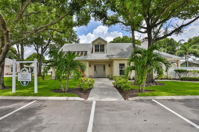 1111 Golfview Woods Dr Unit 1111, Sun City Center, FL 33573 - view of front of home with uncovered parking, a front yard, a shingled roof, a chimney, and stucco siding